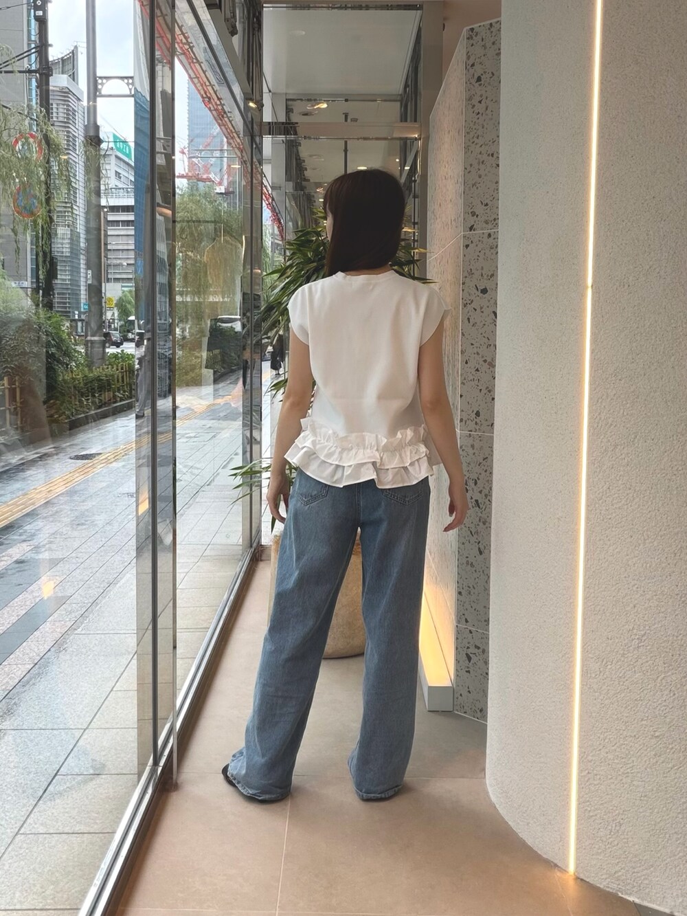 ホワイト系のベスト、ブルー系のデニムパンツ、ブラック系のサンダルを着用したレディースの夏コーディネートの8枚目の写真