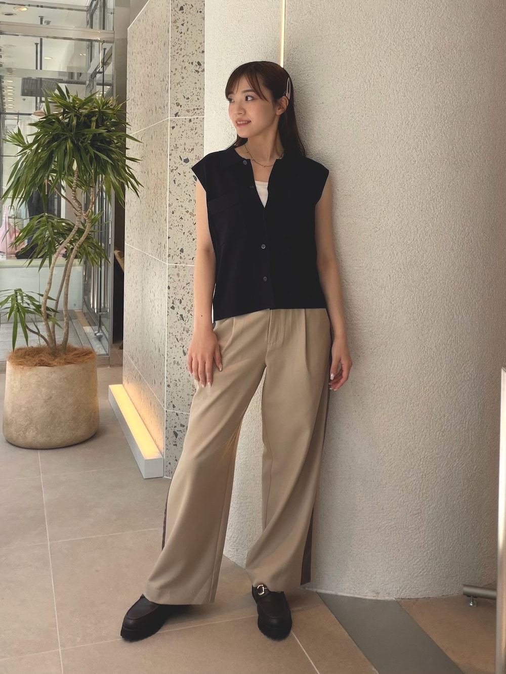 ブルー系のポロシャツ、ベージュ系のその他パンツ、ブラウン系のローファーを着用したレディースの夏コーディネートの3枚目の写真