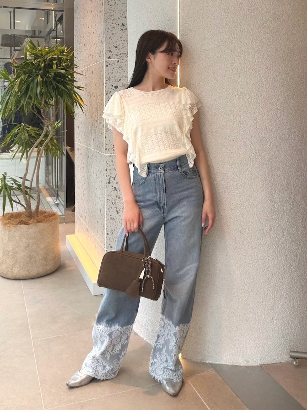 ホワイト系のニット/セーター、ブルー系のデニムパンツ、ベージュ系のボストンバッグを着用したレディースの夏コーディネートの5枚目の写真