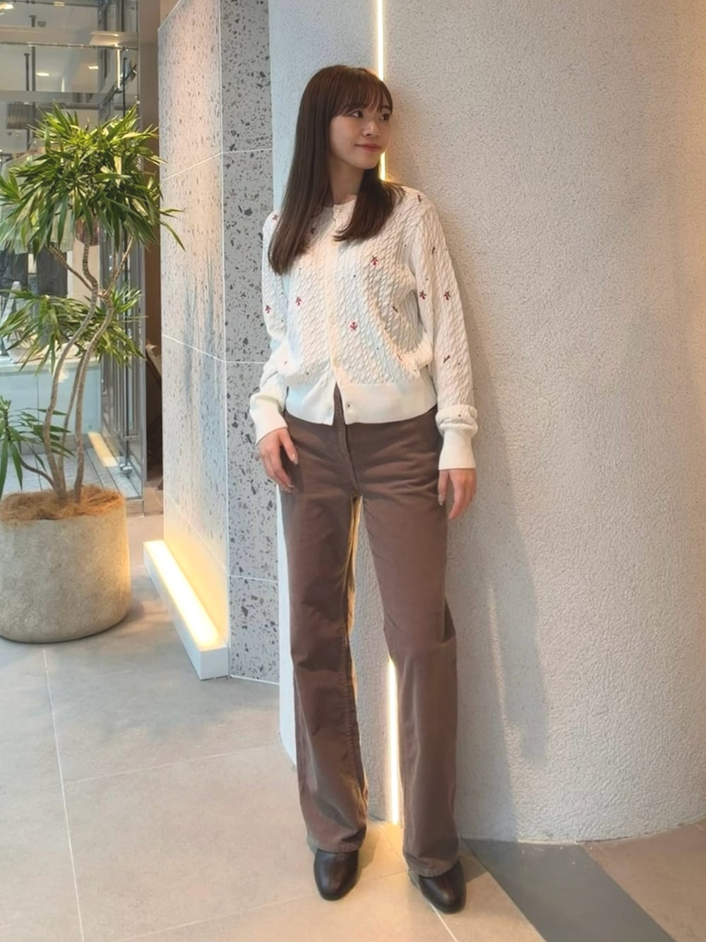 ホワイト系のカーディガン/ボレロ、ブラウン系のその他パンツ、ブラウン系のブーツを着用したレディースの秋コーディネートの6枚目の写真