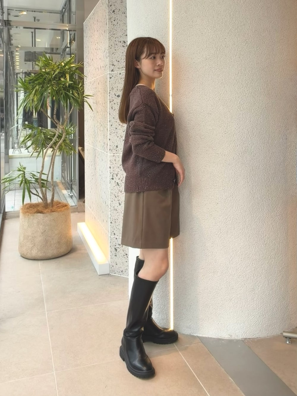 ブラウン系のカーディガン/ボレロ、ブラウン系のその他パンツ、ブラック系のブーツを着用したレディースの秋コーディネートの7枚目の写真