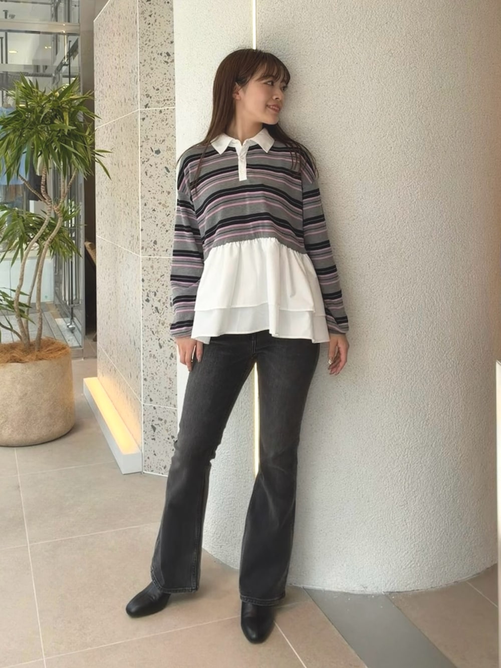 グレー系のニット/セーター、ブラック系のデニムパンツ、ブラック系のブーツを着用したレディースの秋コーディネートの5枚目の写真