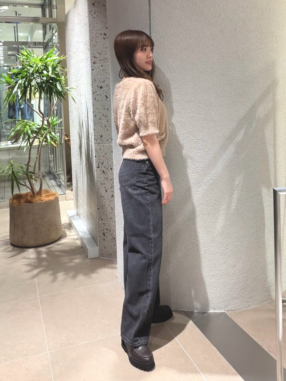 ベージュ系のニット/セーター、ブラック系のデニムパンツ、ブラウン系のローファーを着用したレディースの夏コーディネートの7枚目の写真