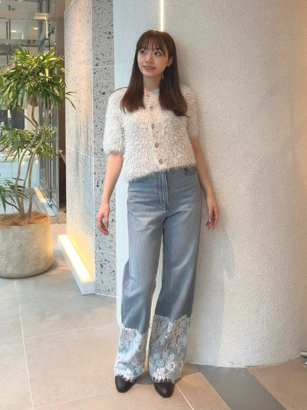 ブルー系のカーディガン/ボレロ、ブルー系のデニムパンツ、ブラウン系のブーツを着用したレディースの秋コーディネートの4枚目の写真