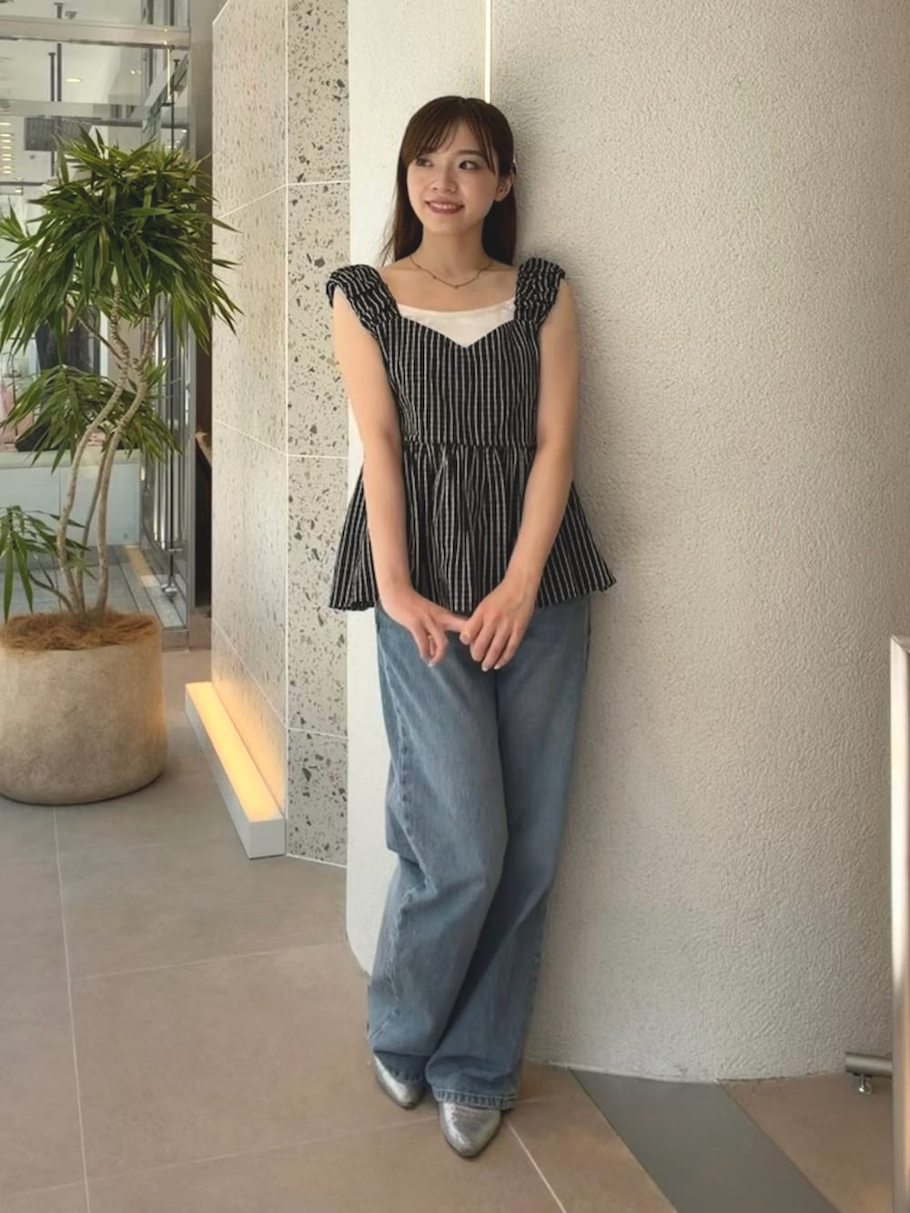 ブラック系のシャツ/ブラウス、ブルー系のデニムパンツを着用したレディースの夏コーディネートの2枚目の写真