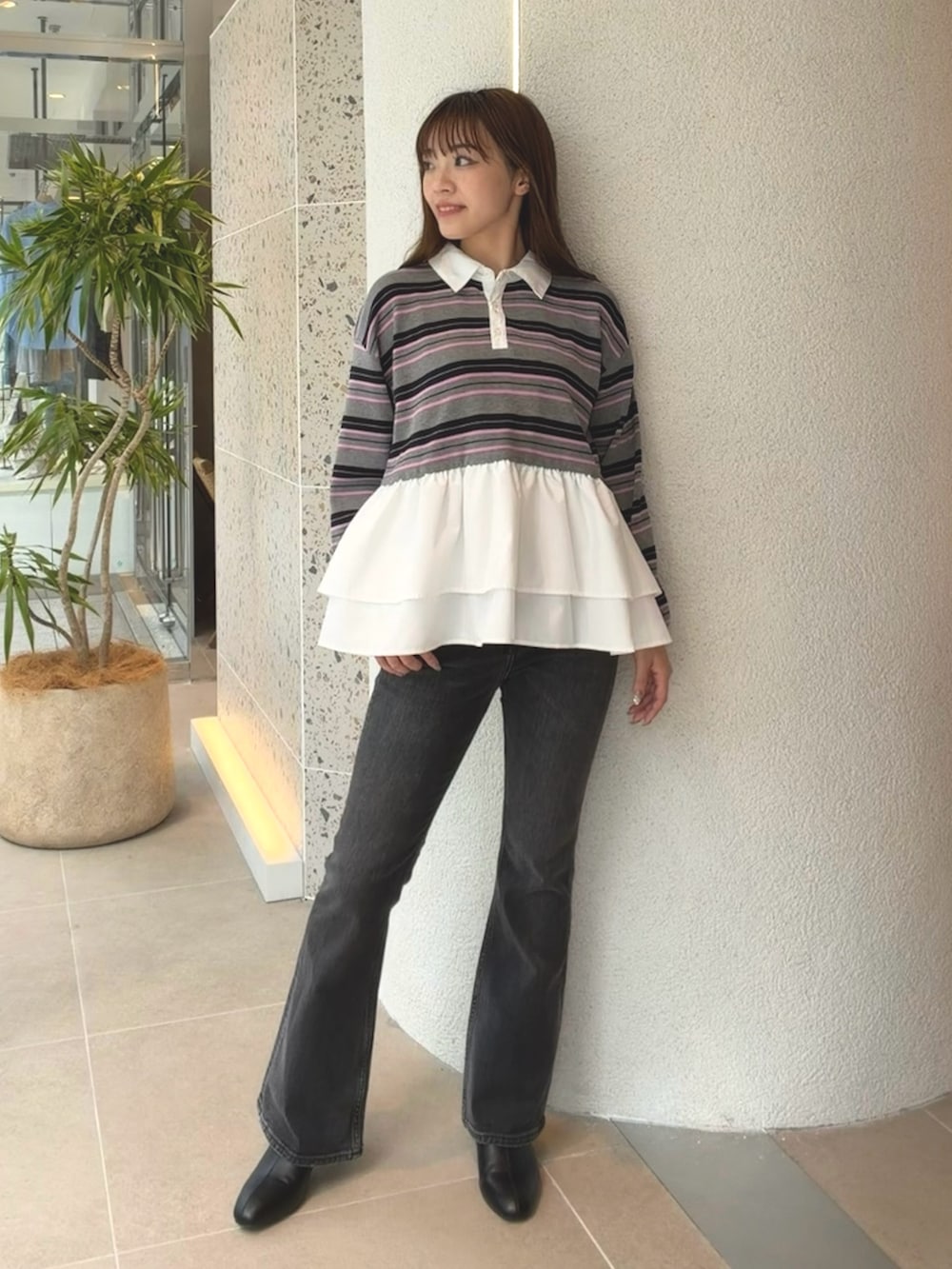 グレー系のニット/セーター、ブラック系のデニムパンツ、ブラック系のブーツを着用したレディースの秋コーディネートの3枚目の写真