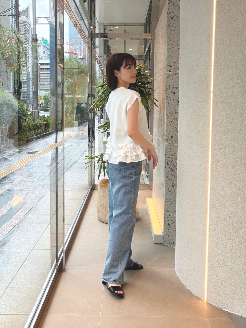 ホワイト系のベスト、ブルー系のデニムパンツ、ブラック系のサンダルを着用したレディースの夏コーディネートの7枚目の写真