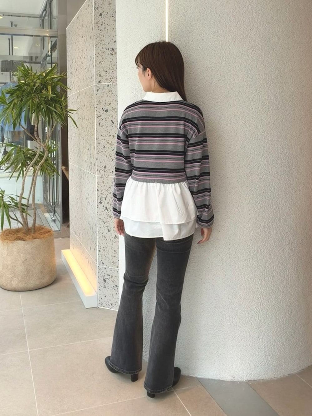 グレー系のニット/セーター、ブラック系のデニムパンツ、ブラック系のブーツを着用したレディースの秋コーディネートの8枚目の写真