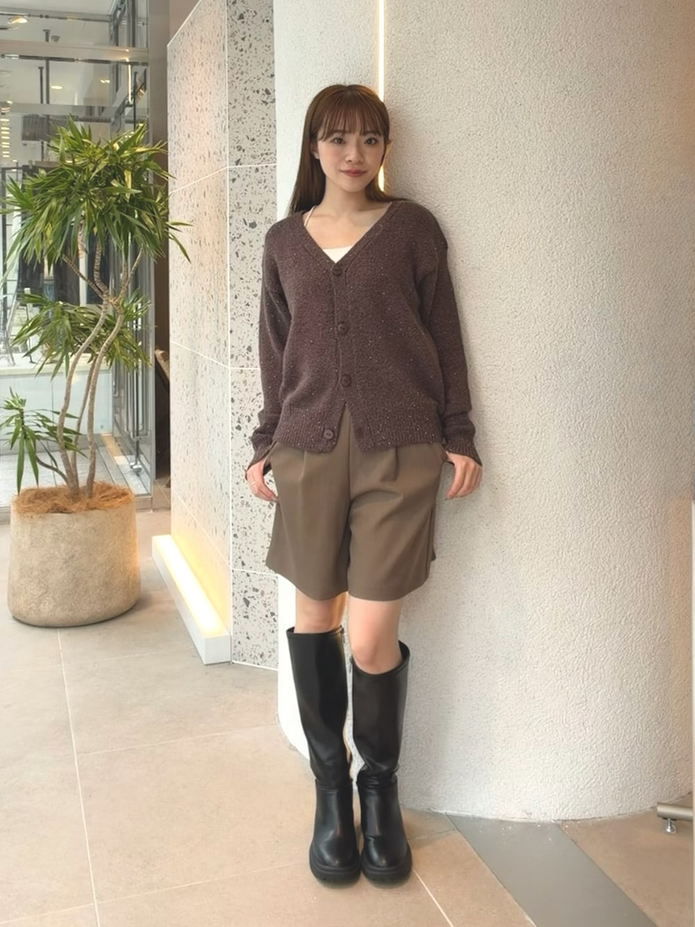 ブラウン系のカーディガン/ボレロ、ブラウン系のその他パンツ、ブラック系のブーツを着用したレディースの秋コーディネートの4枚目の写真
