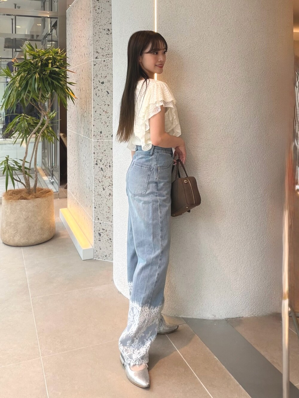 ホワイト系のニット/セーター、ブルー系のデニムパンツ、ベージュ系のボストンバッグを着用したレディースの夏コーディネートの6枚目の写真