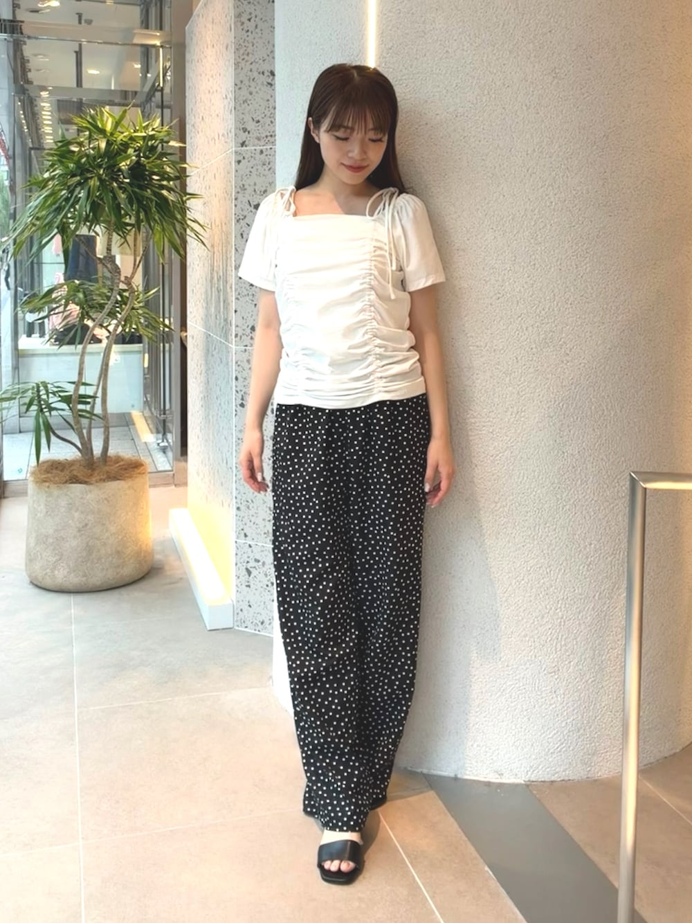 ホワイト系のTシャツ/カットソー、ブラック系のその他パンツ、ブラック系のサンダルを着用したレディースの夏コーディネートの2枚目の写真