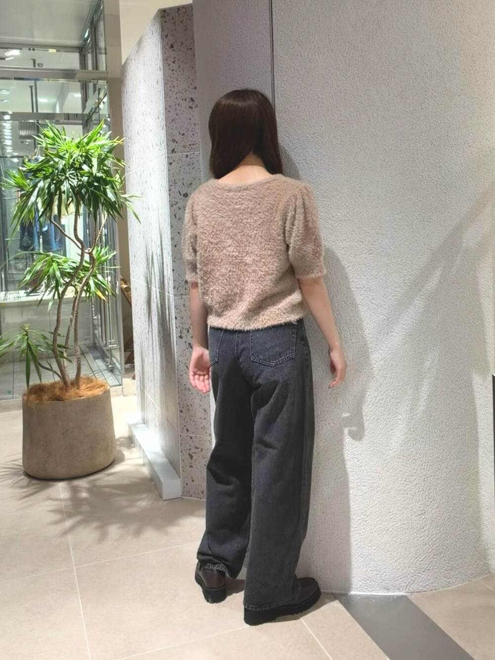 ベージュ系のニット/セーター、ブラック系のデニムパンツ、ブラウン系のローファーを着用したレディースの夏コーディネートの8枚目の写真