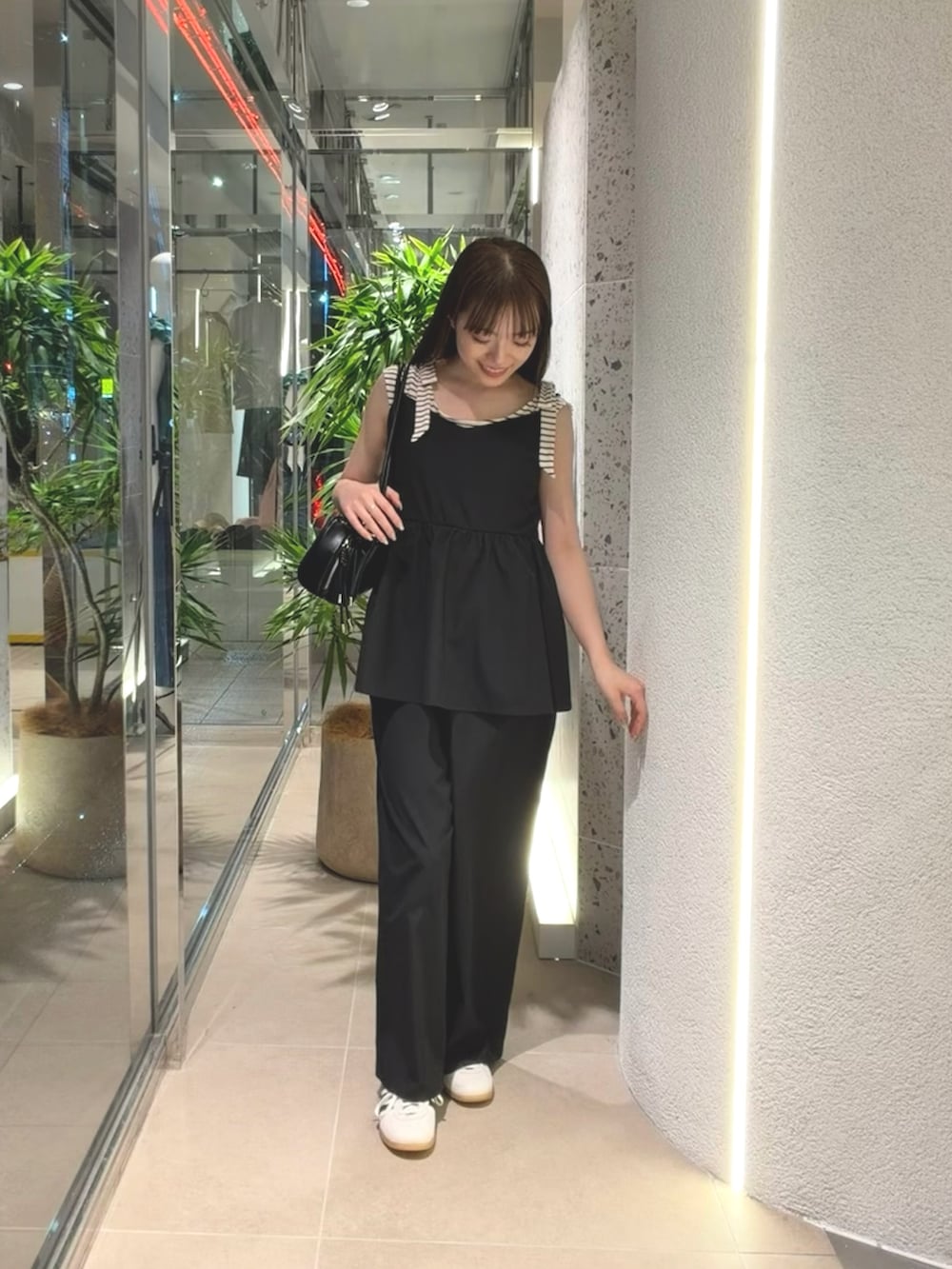 ホワイト系のTシャツ/カットソー、ホワイト系のスニーカー、ブラック系のボストンバッグを着用したレディースの夏コーディネートの4枚目の写真