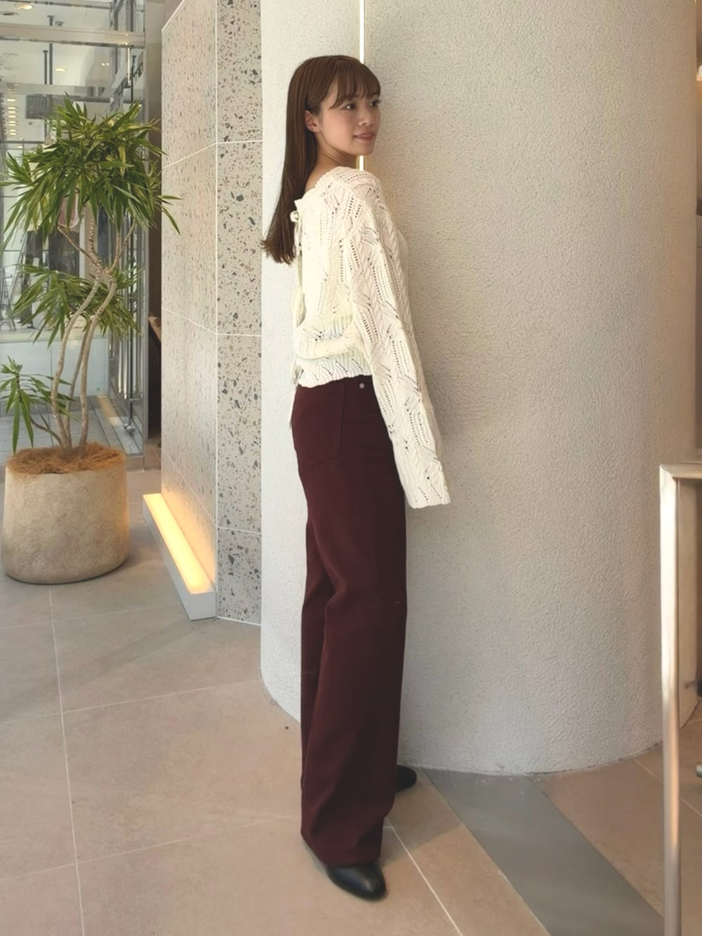ホワイト系のニット/セーター、ブラウン系のその他パンツ、ブラック系のブーツを着用したレディースの秋コーディネートの7枚目の写真