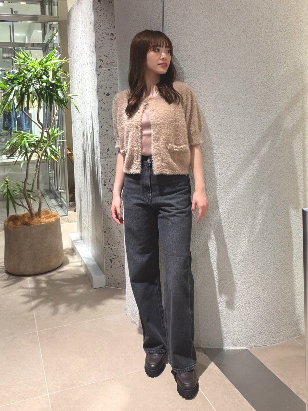 ベージュ系のニット/セーター、ブラック系のデニムパンツ、ブラウン系のローファーを着用したレディースの夏コーディネートの6枚目の写真