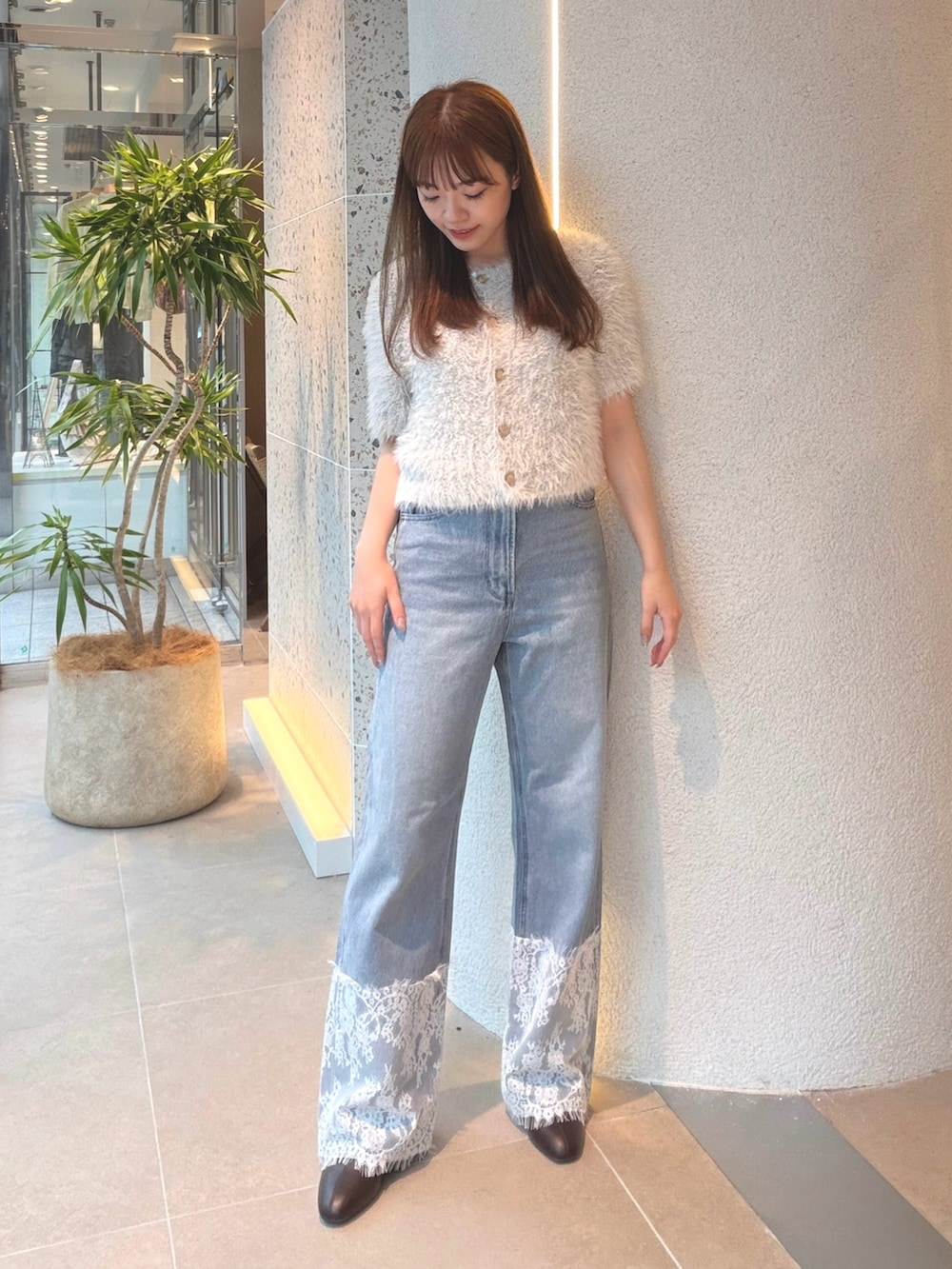 ブルー系のカーディガン/ボレロ、ブルー系のデニムパンツ、ブラウン系のブーツを着用したレディースの秋コーディネートの5枚目の写真