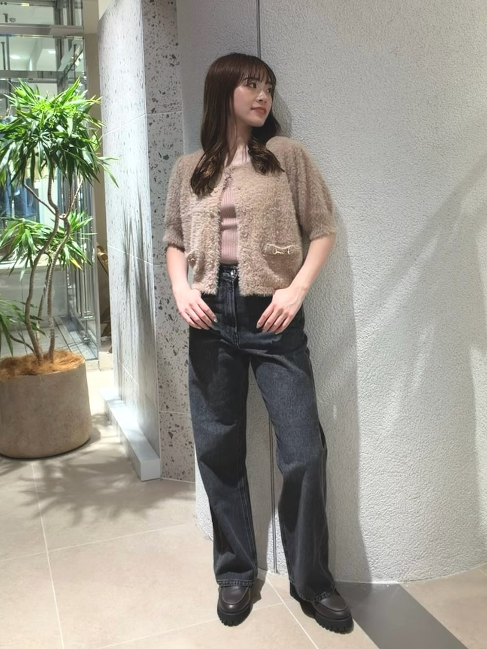 ベージュ系のニット/セーター、ブラック系のデニムパンツ、ブラウン系のローファーを着用したレディースの夏コーディネートの3枚目の写真