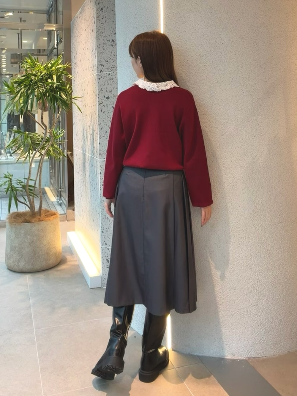 レッド系のカーディガン/ボレロ、グレー系のスカート、ブラック系のブーツを着用したレディースの秋コーディネートの8枚目の写真