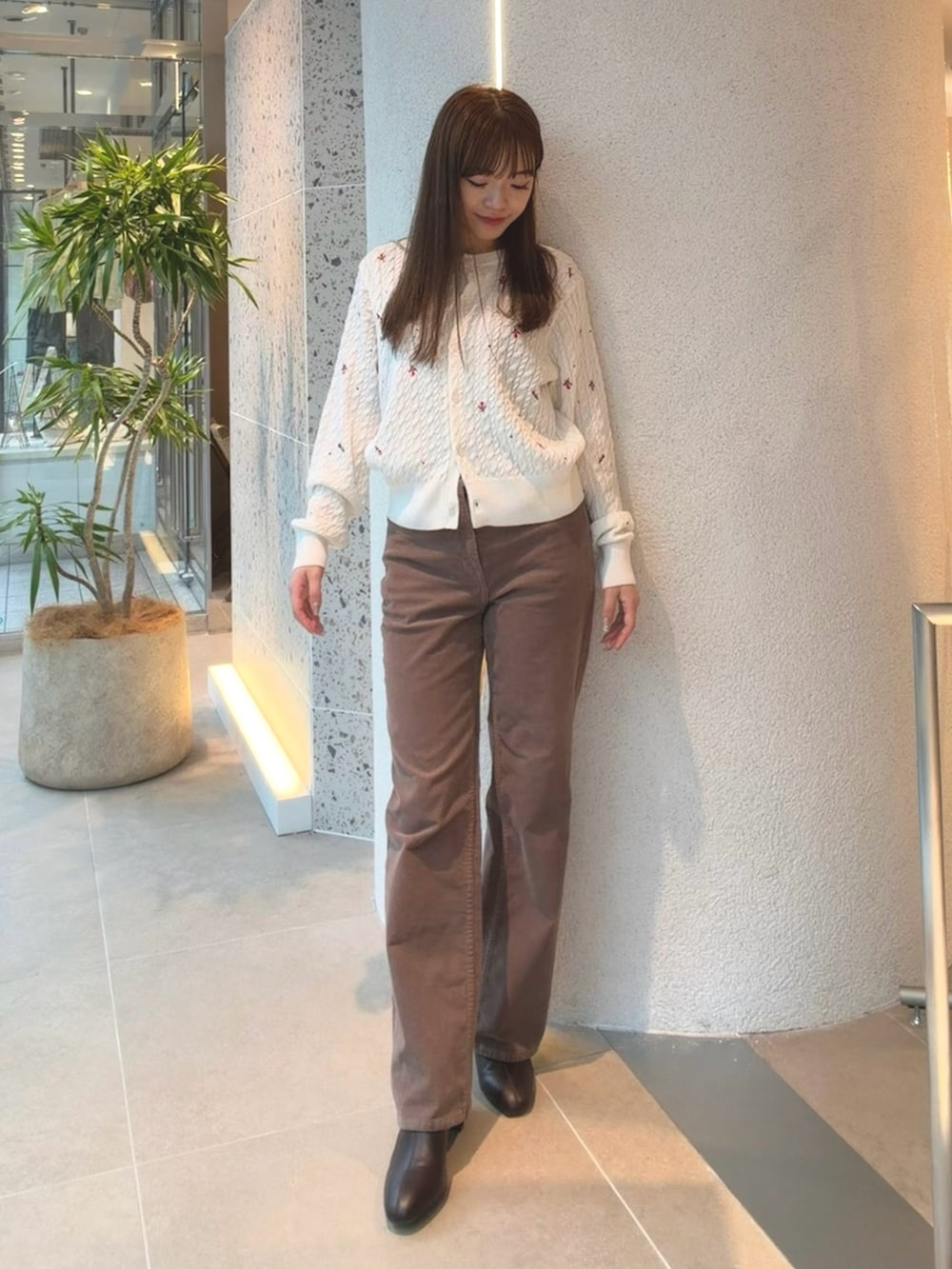 ホワイト系のカーディガン/ボレロ、ブラウン系のその他パンツ、ブラウン系のブーツを着用したレディースの秋コーディネートの3枚目の写真