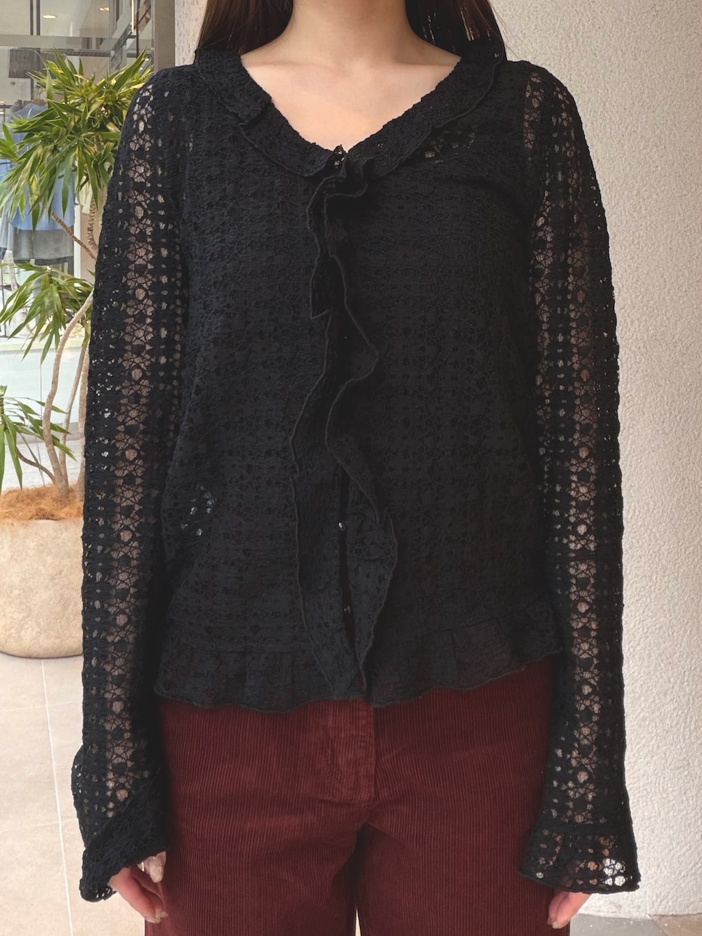 ブラック系のカーディガン/ボレロ、レッド系のその他パンツ、ブラック系のブーツを着用したレディースの秋コーディネートの9枚目の写真
