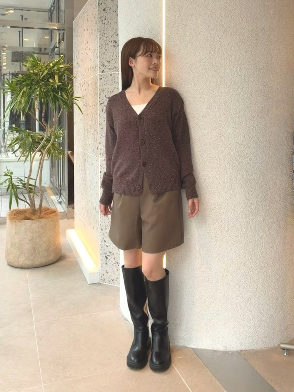 ブラウン系のカーディガン/ボレロ、ブラウン系のその他パンツ、ブラック系のブーツを着用したレディースの秋コーディネートの2枚目の写真