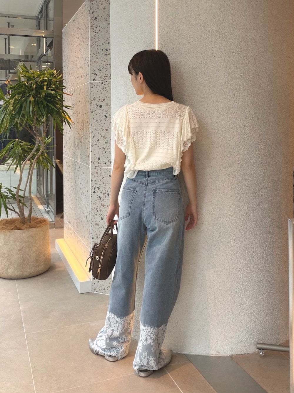 ホワイト系のニット/セーター、ブルー系のデニムパンツ、ベージュ系のボストンバッグを着用したレディースの夏コーディネートの7枚目の写真