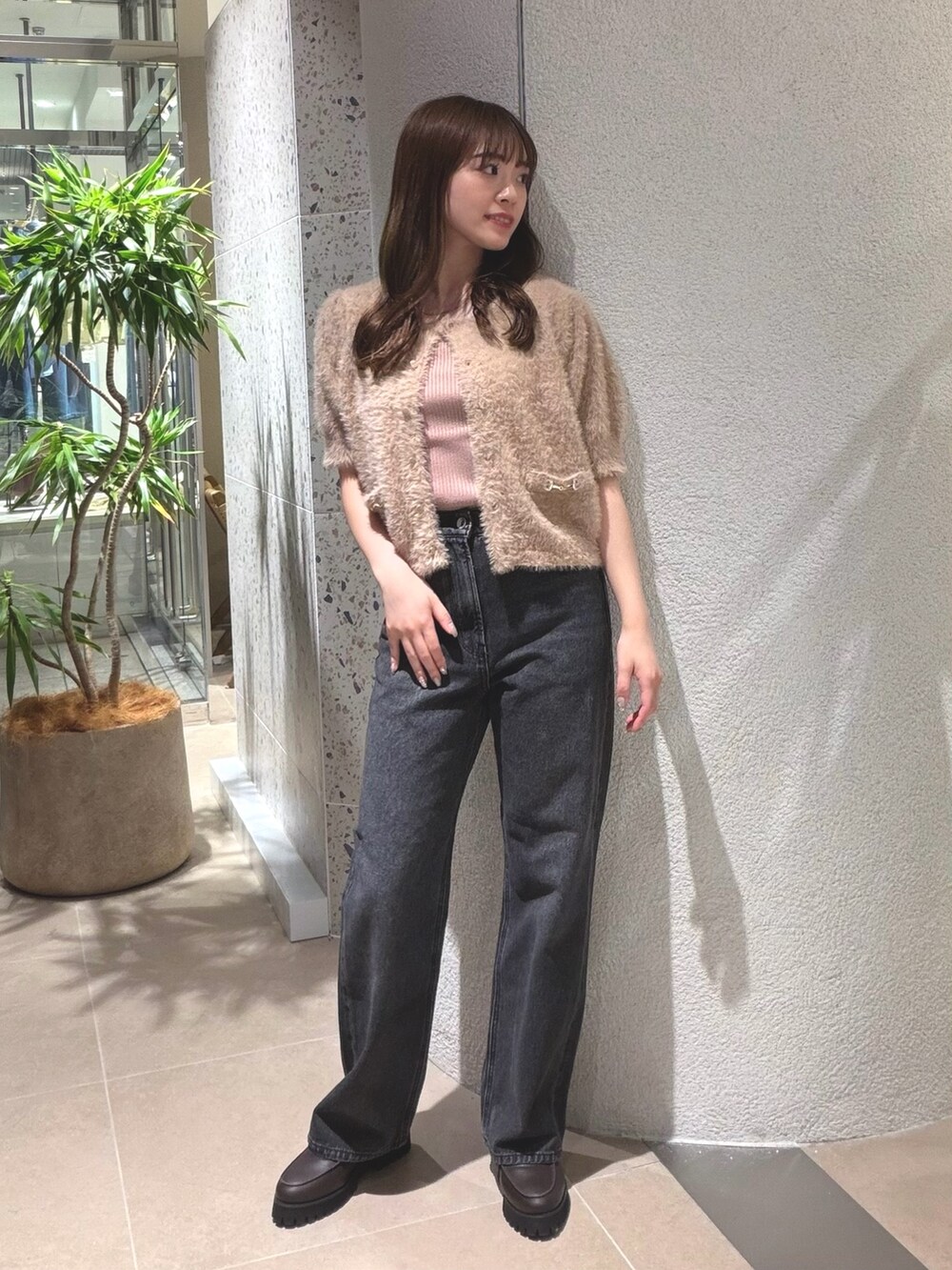 ベージュ系のニット/セーター、ブラック系のデニムパンツ、ブラウン系のローファーを着用したレディースの夏コーディネートの5枚目の写真