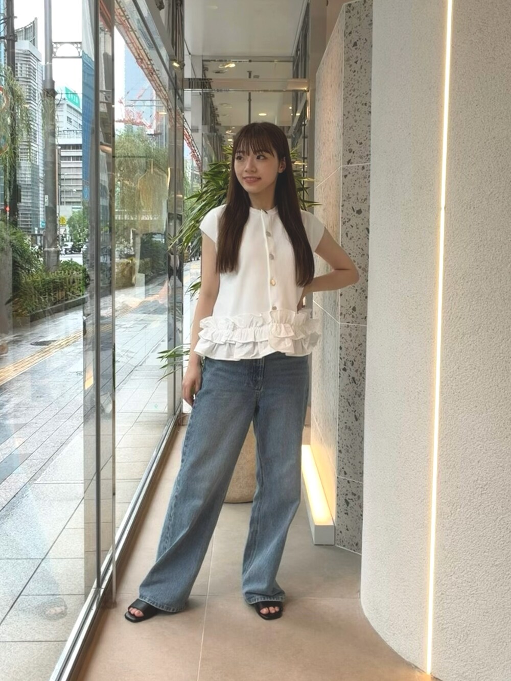 ホワイト系のベスト、ブルー系のデニムパンツ、ブラック系のサンダルを着用したレディースの夏コーディネートの5枚目の写真