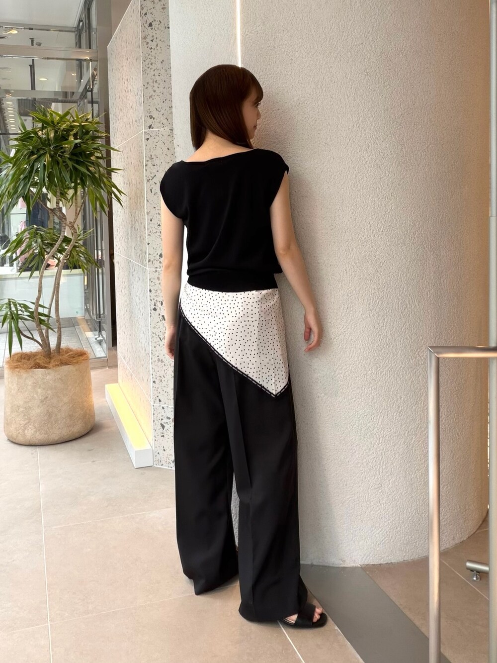ブラック系のニット/セーター、ブラック系のその他パンツ、ブラック系のサンダルを着用したレディースの夏コーディネートの6枚目の写真
