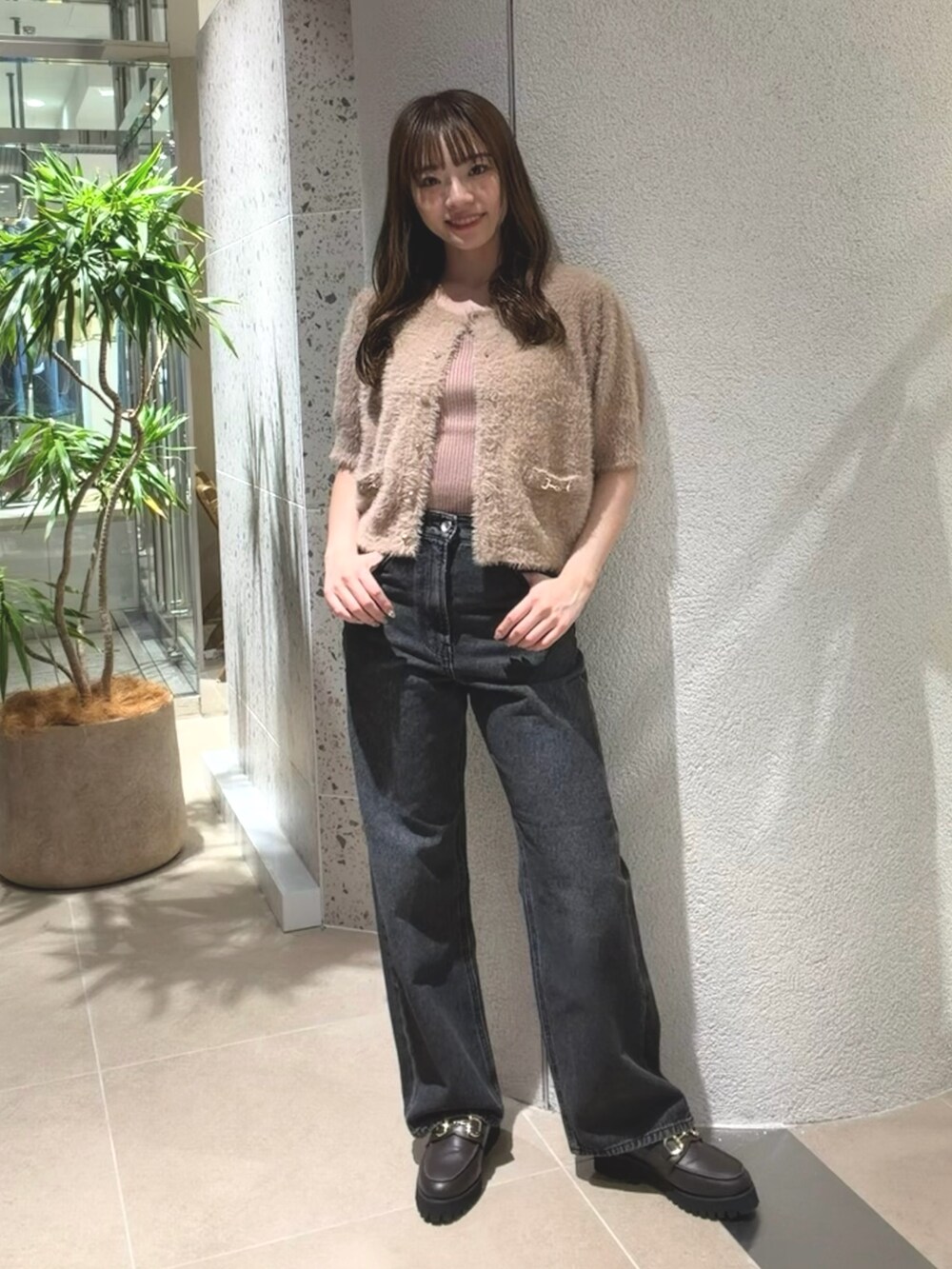 ベージュ系のニット/セーター、ブラック系のデニムパンツ、ブラウン系のローファーを着用したレディースの夏コーディネートの2枚目の写真