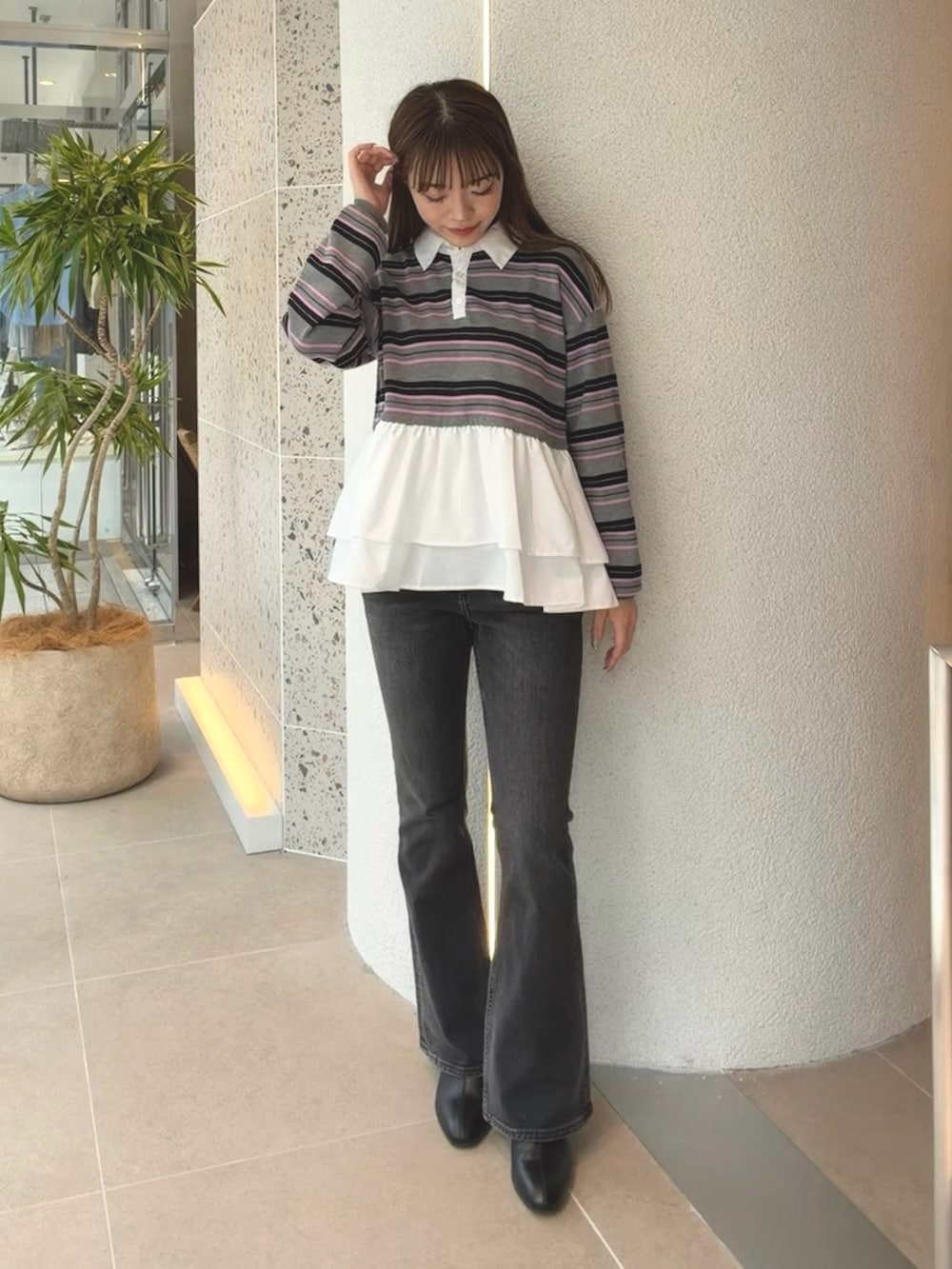 グレー系のニット/セーター、ブラック系のデニムパンツ、ブラック系のブーツを着用したレディースの秋コーディネートの4枚目の写真