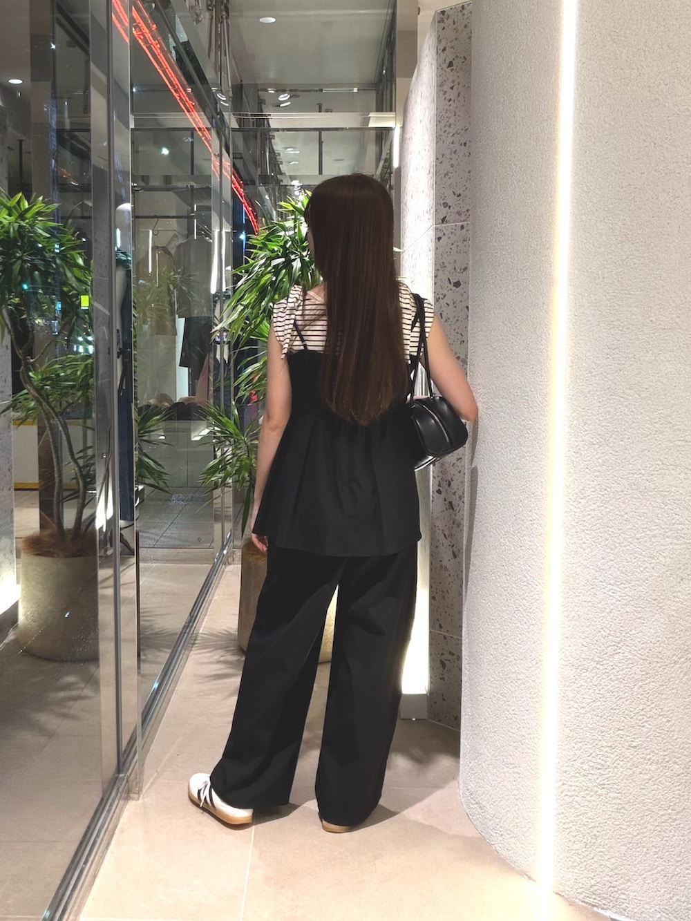 ホワイト系のTシャツ/カットソー、ホワイト系のスニーカー、ブラック系のボストンバッグを着用したレディースの夏コーディネートの6枚目の写真