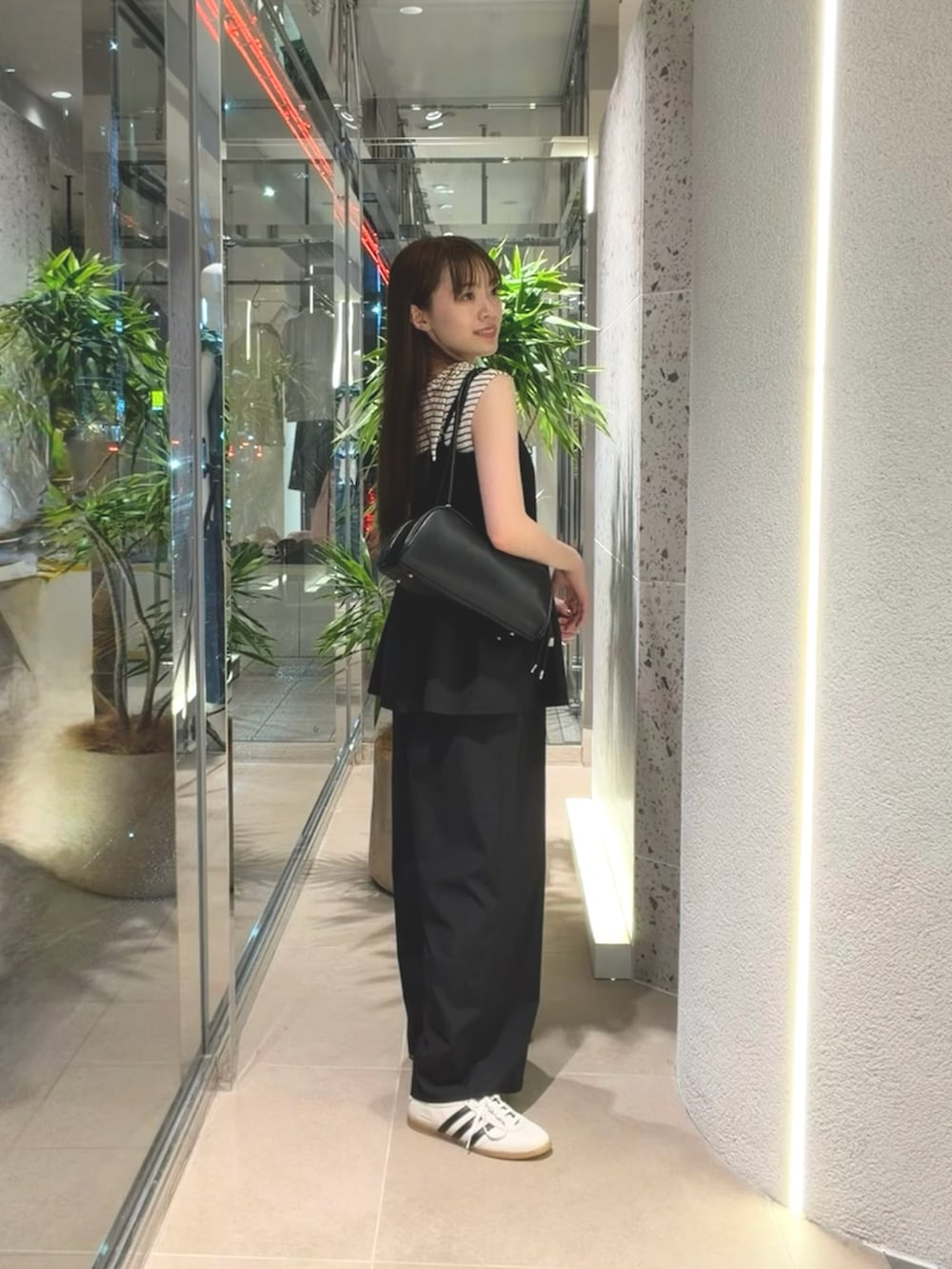 ホワイト系のTシャツ/カットソー、ホワイト系のスニーカー、ブラック系のボストンバッグを着用したレディースの夏コーディネートの5枚目の写真