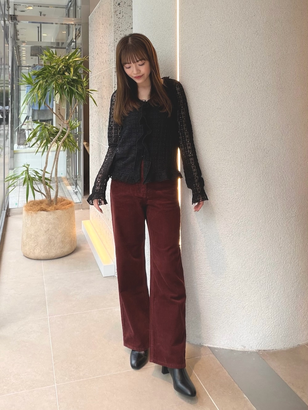 ブラック系のカーディガン/ボレロ、レッド系のその他パンツ、ブラック系のブーツを着用したレディースの秋コーディネートの2枚目の写真