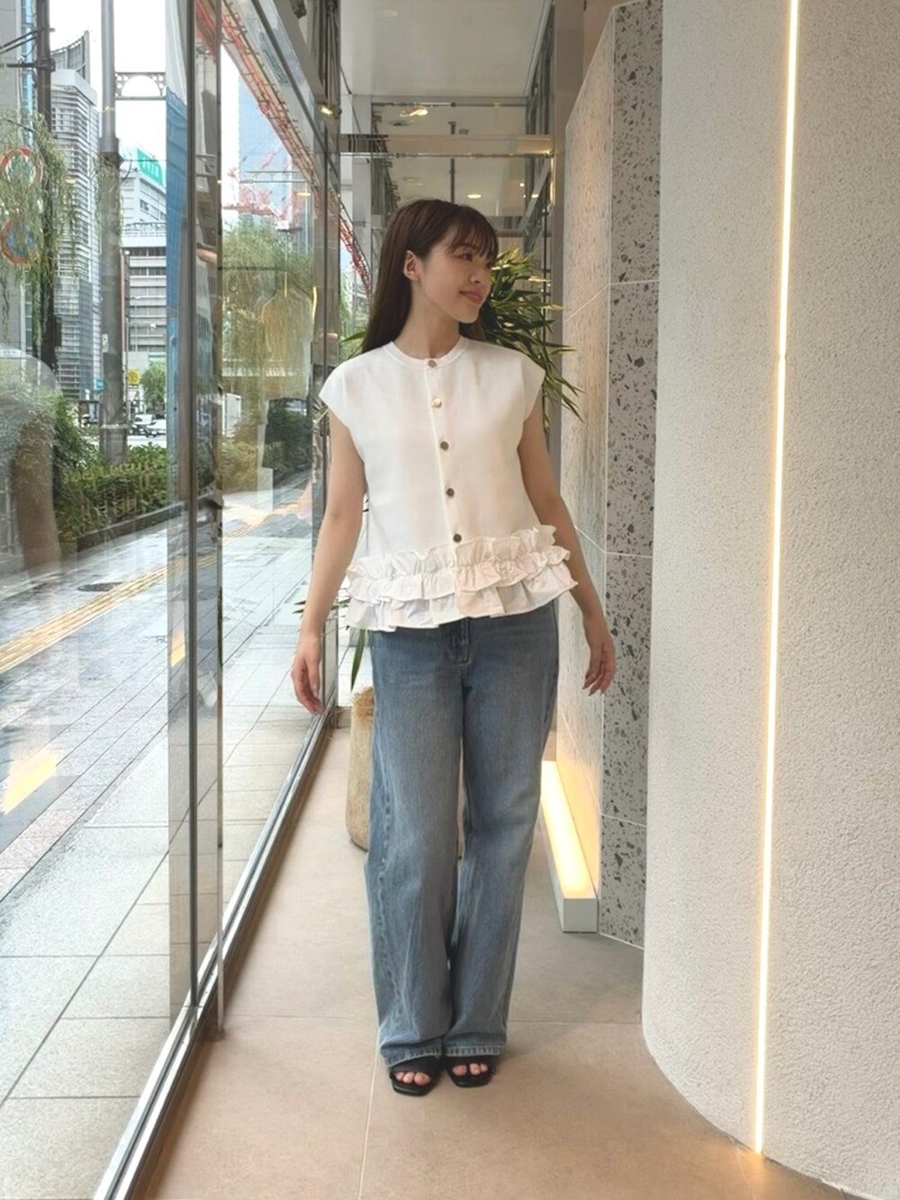ホワイト系のベスト、ブルー系のデニムパンツ、ブラック系のサンダルを着用したレディースの夏コーディネートの6枚目の写真