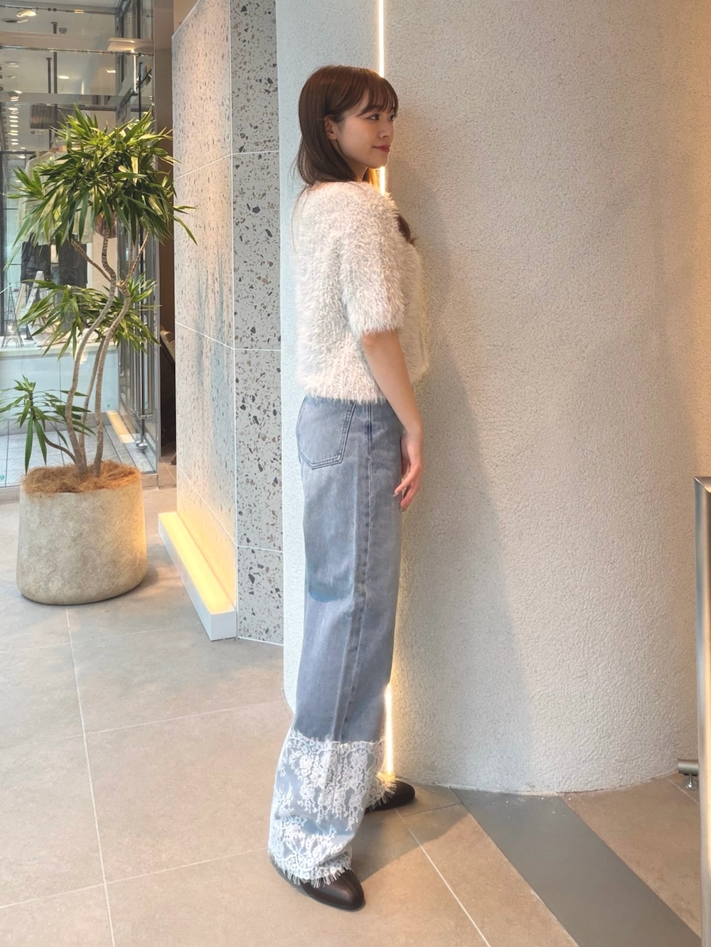 ブルー系のカーディガン/ボレロ、ブルー系のデニムパンツ、ブラウン系のブーツを着用したレディースの秋コーディネートの6枚目の写真