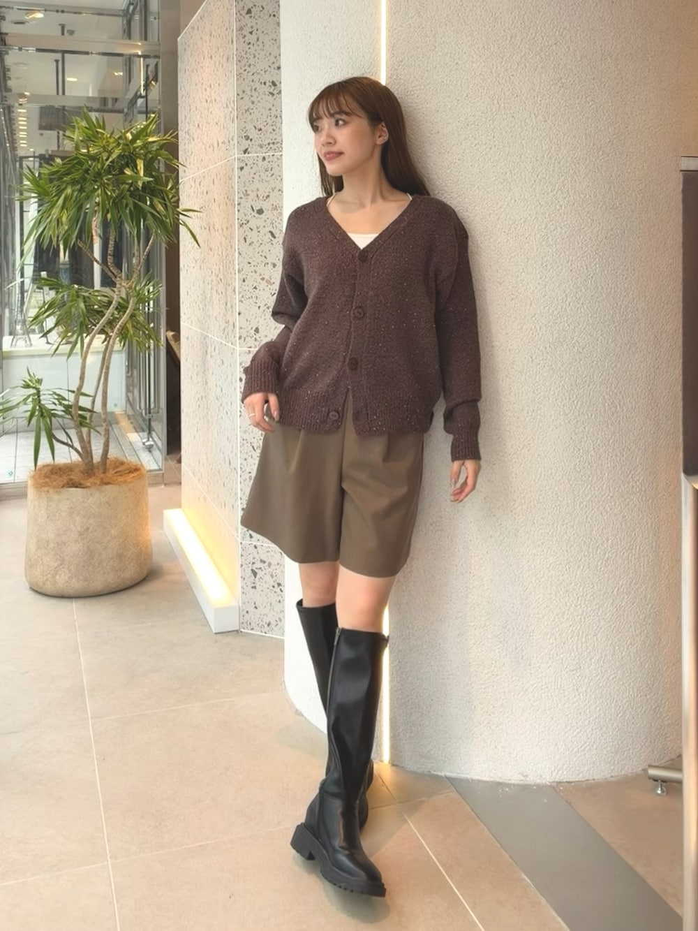 ブラウン系のカーディガン/ボレロ、ブラウン系のその他パンツ、ブラック系のブーツを着用したレディースの秋コーディネートの5枚目の写真