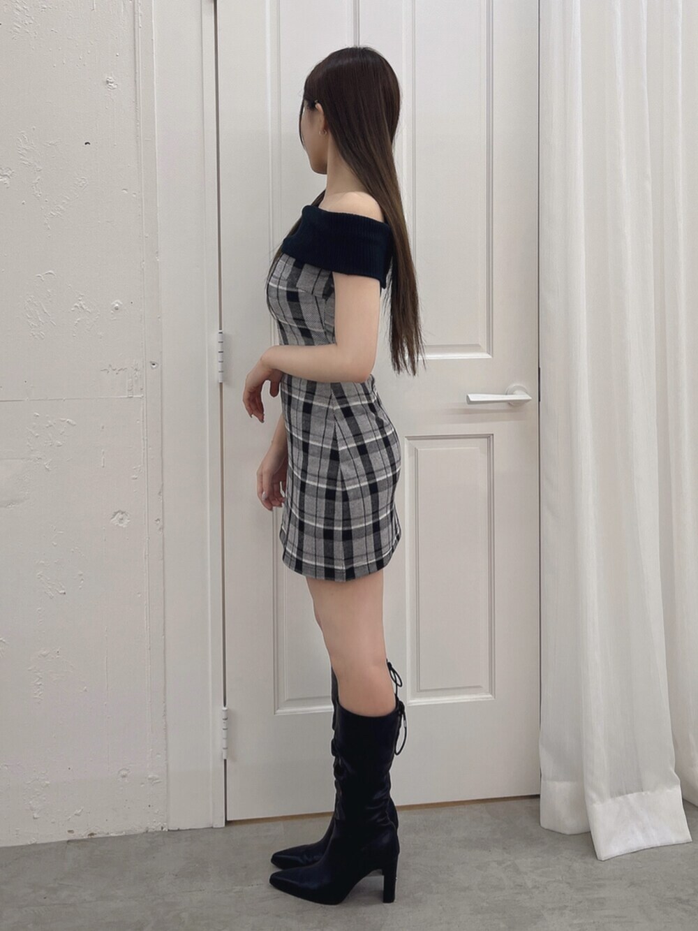 ブラック系のワンピース、ブラック系のブーツを着用したレディースの夏コーディネートの3枚目の写真