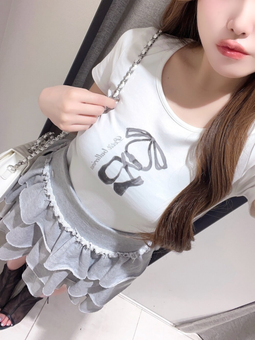 グレー系のスカート、ホワイト系のTシャツ/カットソー、ホワイト系のショルダーバッグを着用したレディースの夏コーディネートの6枚目の写真