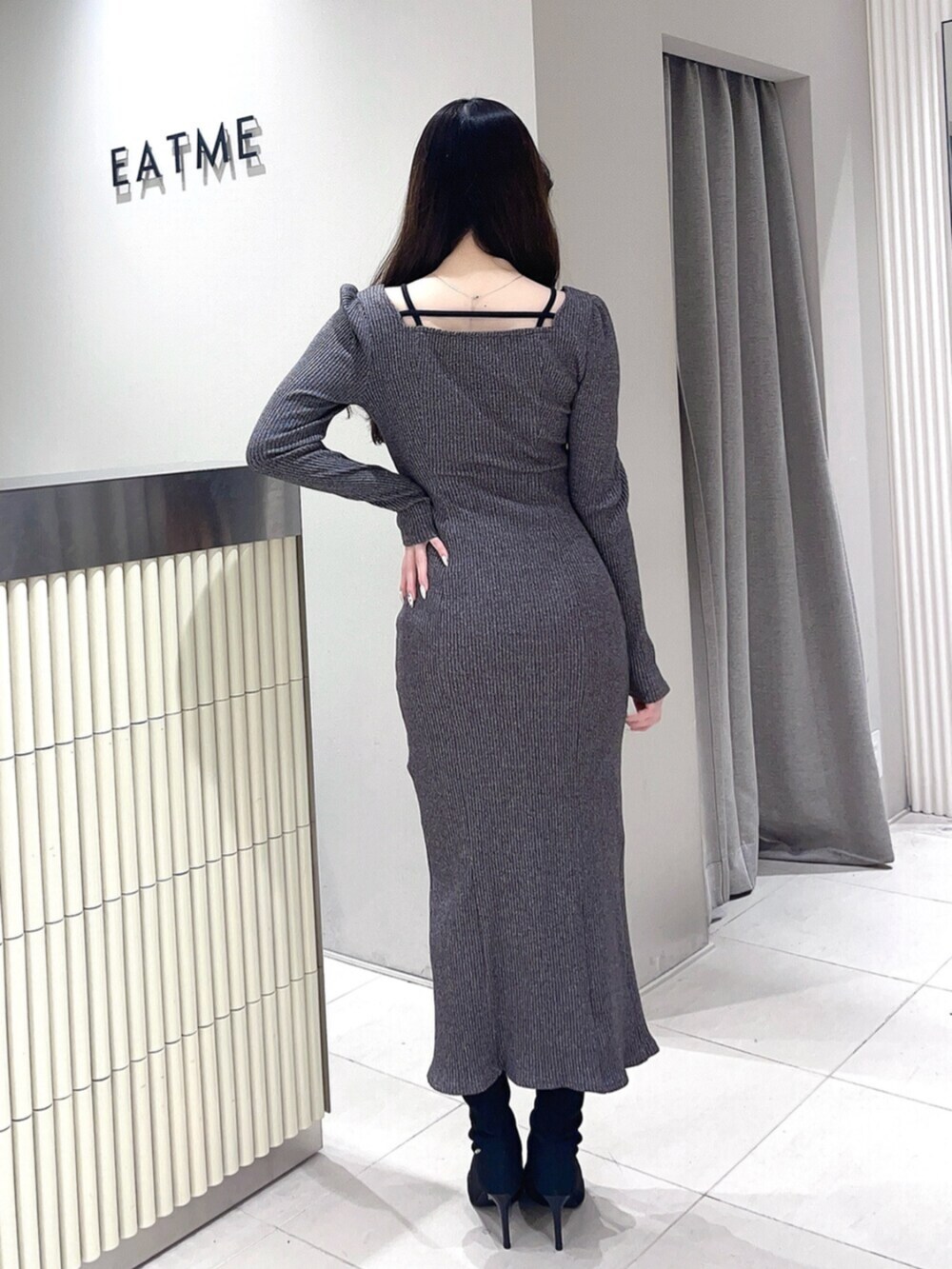 ブラック系のブーツ、グレー系のワンピースを着用したレディースの冬コーディネートの3枚目の写真