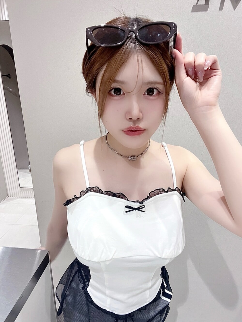 ホワイト系のキャミソール、ホワイト系のスカート、ブラック系のサンダルを着用したレディースの夏コーディネートの4枚目の写真