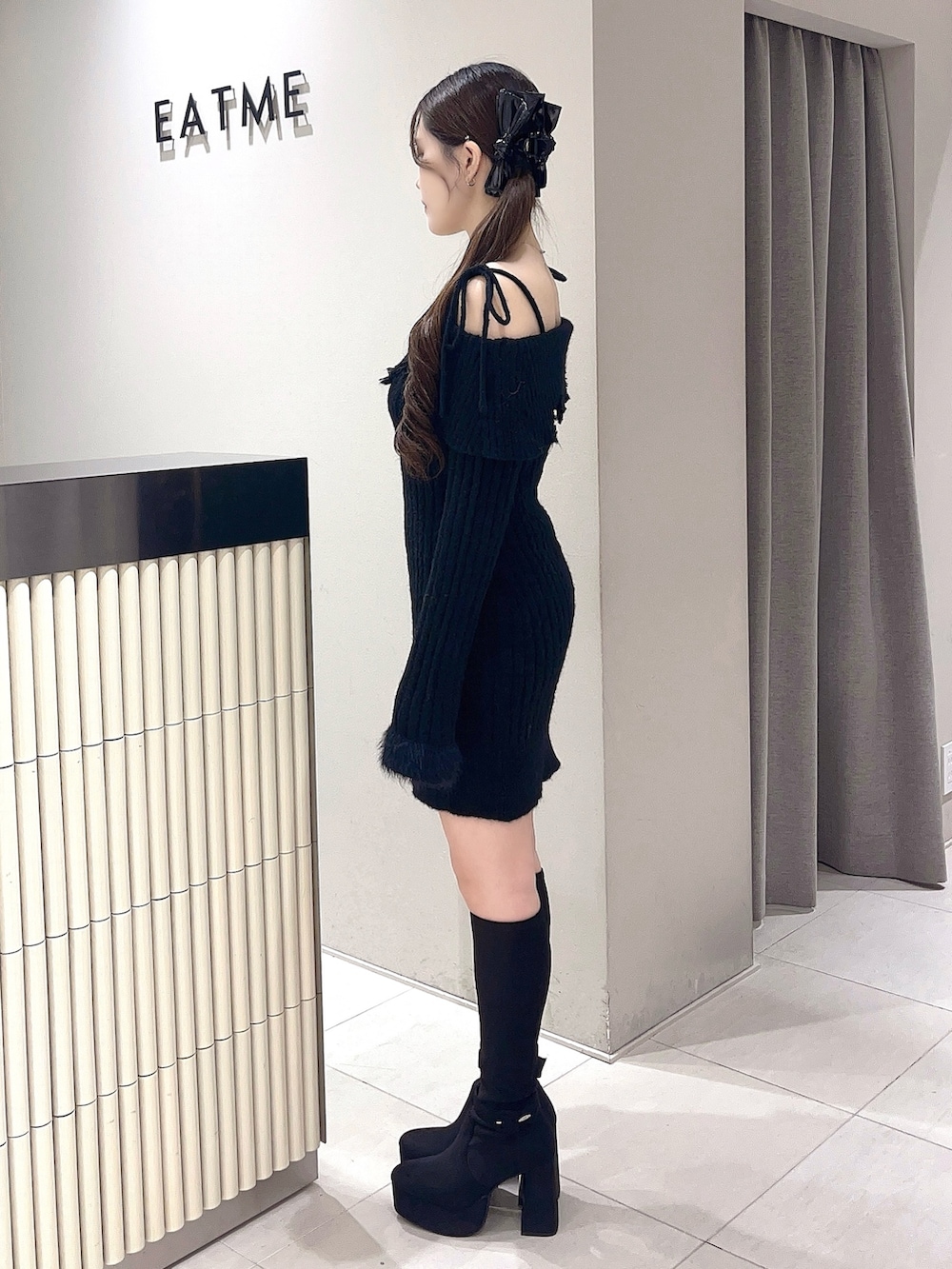 ブラック系のワンピース、ブラック系のブーツ、ブラック系のバレッタ/ヘアクリップを着用したレディースの秋コーディネートの2枚目の写真