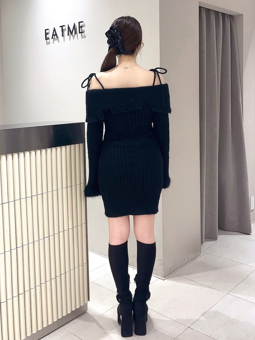 ブラック系のワンピース、ブラック系のブーツ、ブラック系のバレッタ/ヘアクリップを着用したレディースの秋コーディネートの3枚目の写真