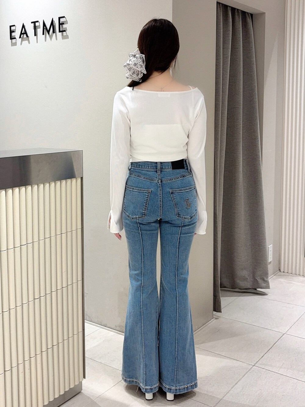 ホワイト系のTシャツ/カットソー、ブルー系のデニムパンツ、ホワイト系のブーツを着用したレディースの春コーディネートの3枚目の写真