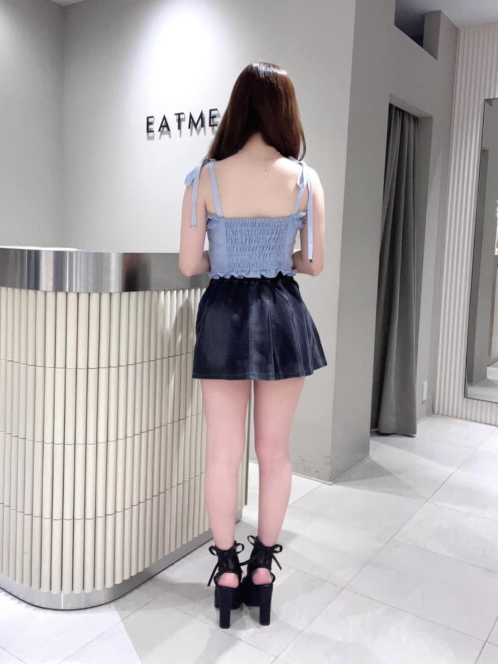 ブルー系のキャミソール、ブラック系のデニムスカート、ブラック系のサンダルを着用したレディースの春コーディネートの4枚目の写真