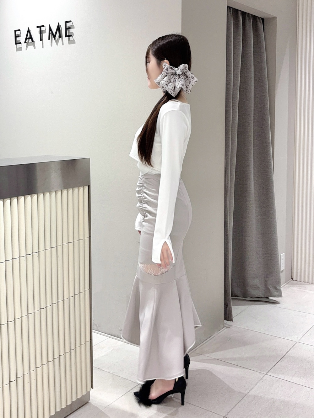 ホワイト系のTシャツ/カットソー、グレー系のスカート、ブラック系のサンダルを着用したレディースの春コーディネートの2枚目の写真