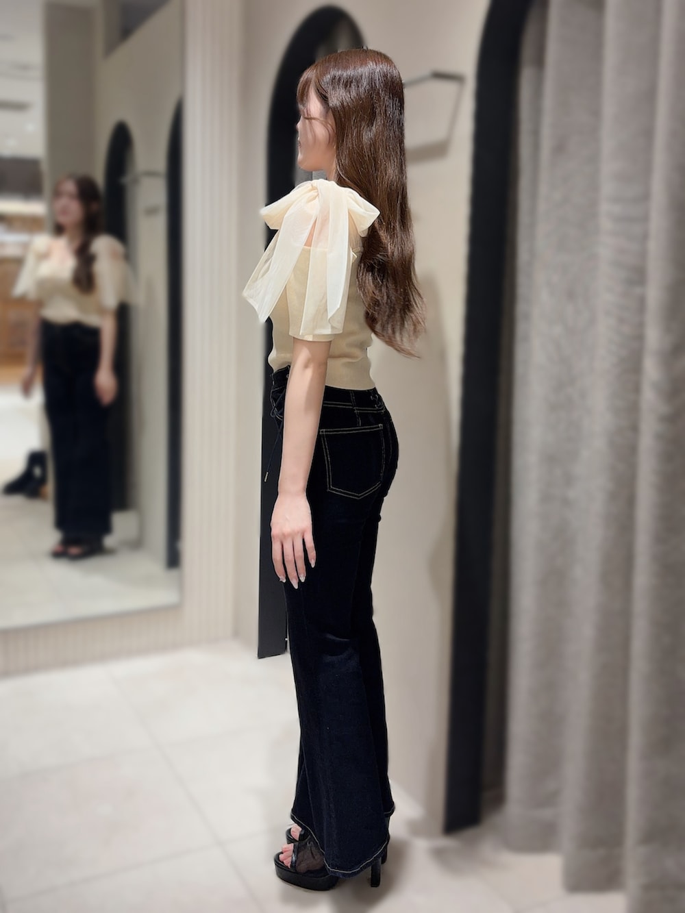 ホワイト系のTシャツ/カットソー、ブルー系のデニムパンツ、ブラック系のサンダルを着用したレディースの春コーディネートの2枚目の写真