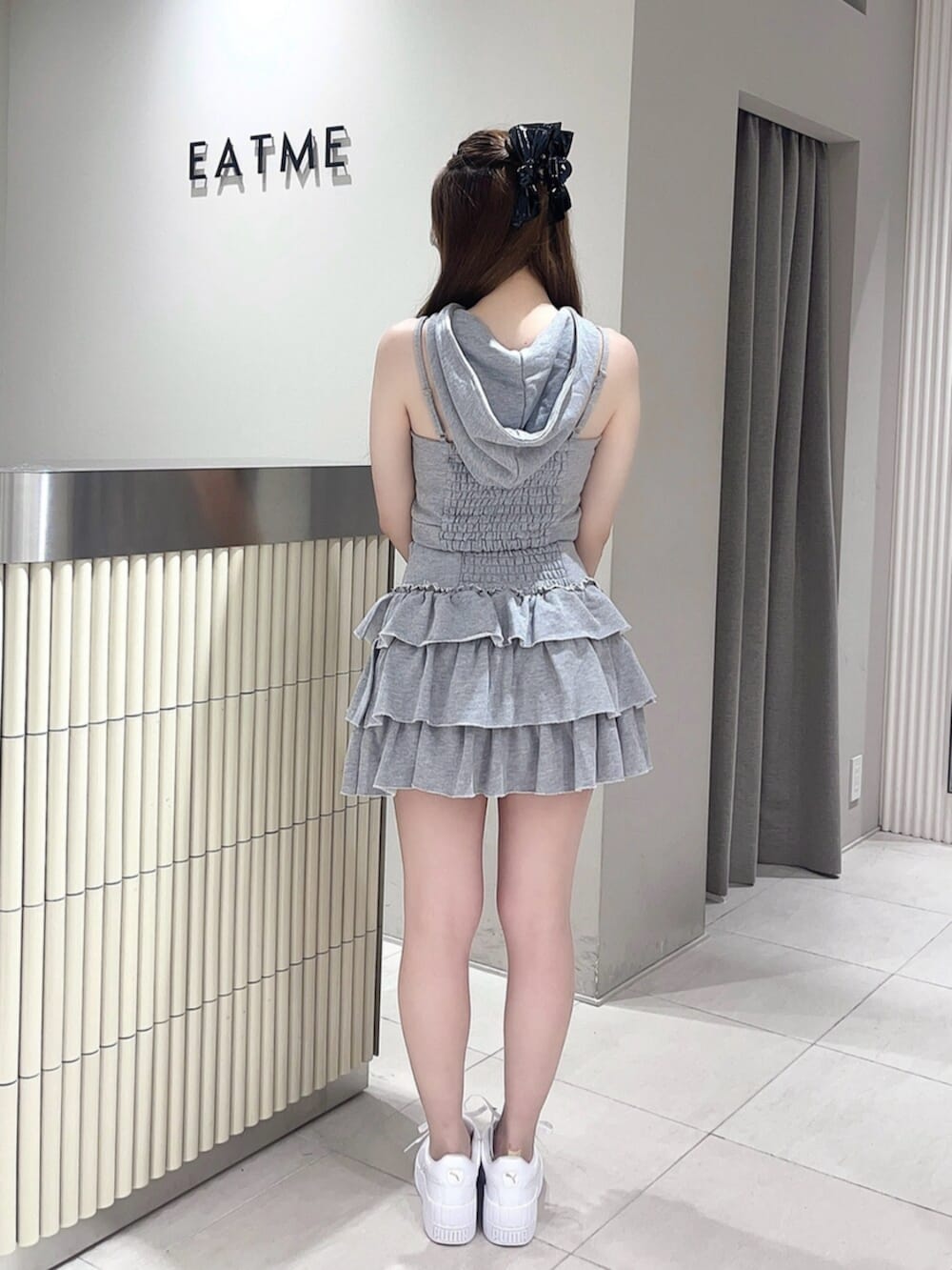 グレー系のキャミソール、グレー系のスカート、ホワイト系のスニーカーを着用したレディースの夏コーディネートの3枚目の写真