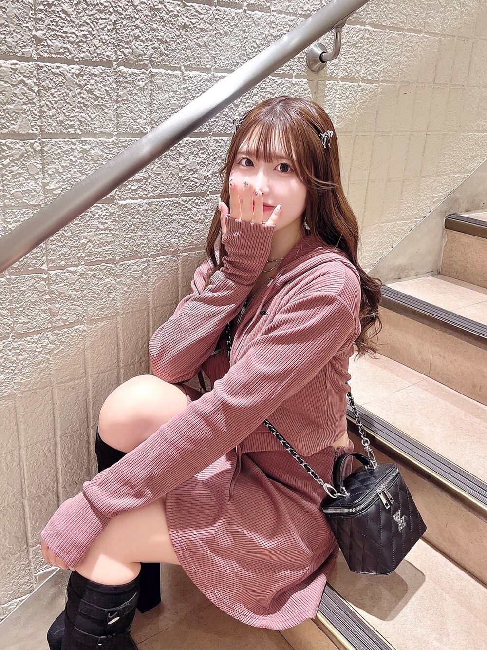 ピンク系のパーカー、ピンク系のスカート、ブラック系のハンドバッグを着用したレディースの秋コーディネートの2枚目の写真