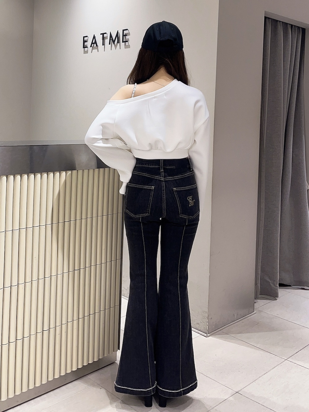 ホワイト系のスウェット、ブラック系のデニムパンツ、ブラック系のブーツを着用したレディースの春コーディネートの3枚目の写真